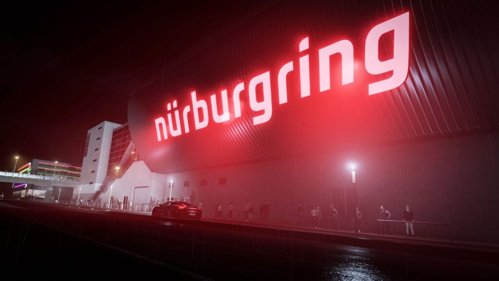 Assetto Corsa EVO prepara Free Roam en el Eifel a escala real Fachada iluminada del Nürburgring por la noche, con un coche delante del edificio.