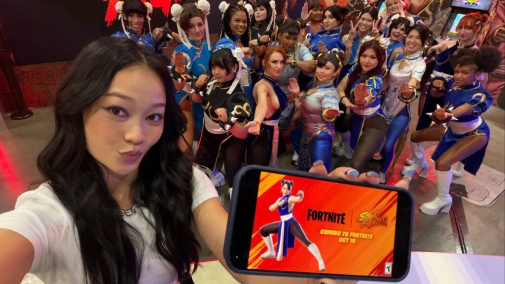 Callina Liang junto a cosplayers de Chun-Li, mostrando en un móvil el nuevo atuendo de Fortnite.