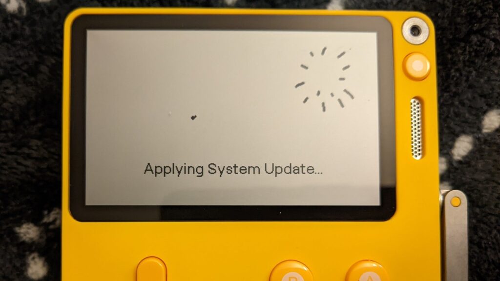 Playdate mostrando el mensaje «Applying System Update» durante una actualización del sistema.